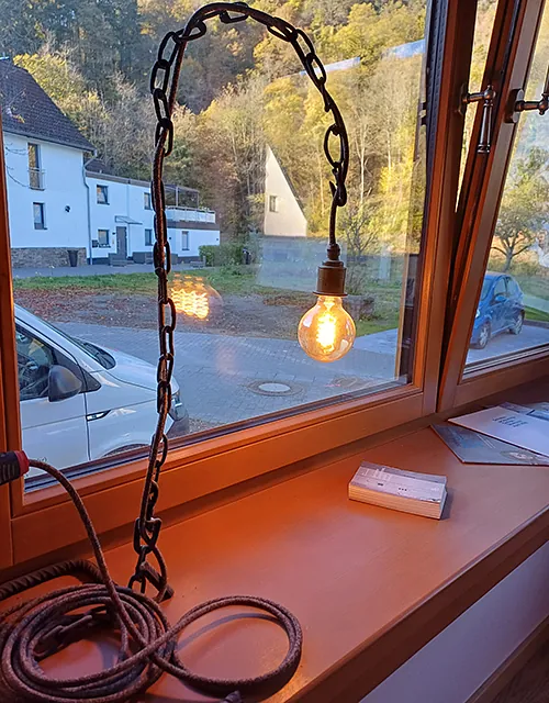 Ein Fenster, hinter dem eine Lampe leuchtet und eine gemütliche Atmosphäre schafft. 