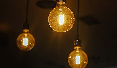 An der Decke hängen drei Lichtquellen in Form von Glühbirnen. 