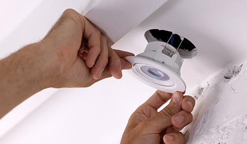 Eine Person installiert eine Lichtleiste an der Wand.